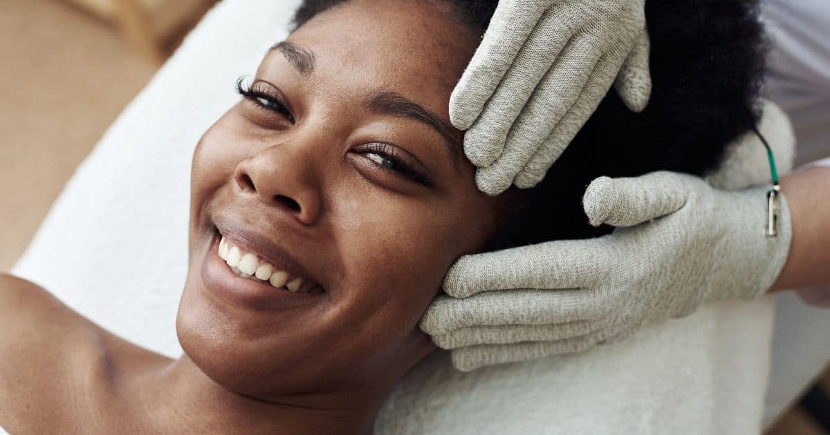 woman laying down getting microcurrent facial