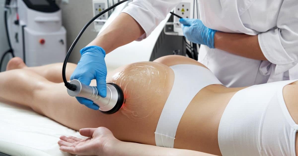 therapist applying cavitation to lady right glute.