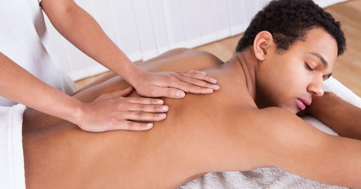 Teen receiving a professional back massage with appropriate draping at Somatic Massage Therapy & Spa.