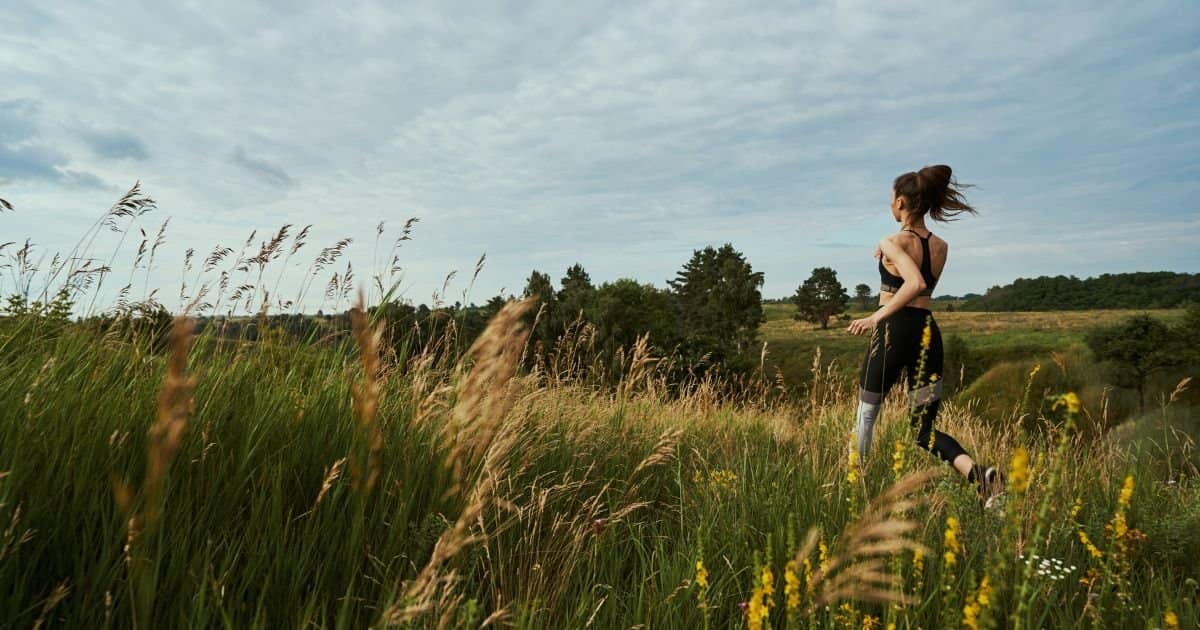 woman jogging through a field