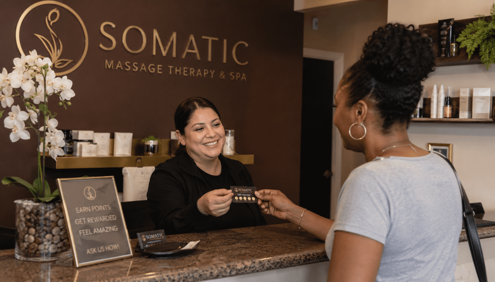 woman exchanging gift card at the spa desk