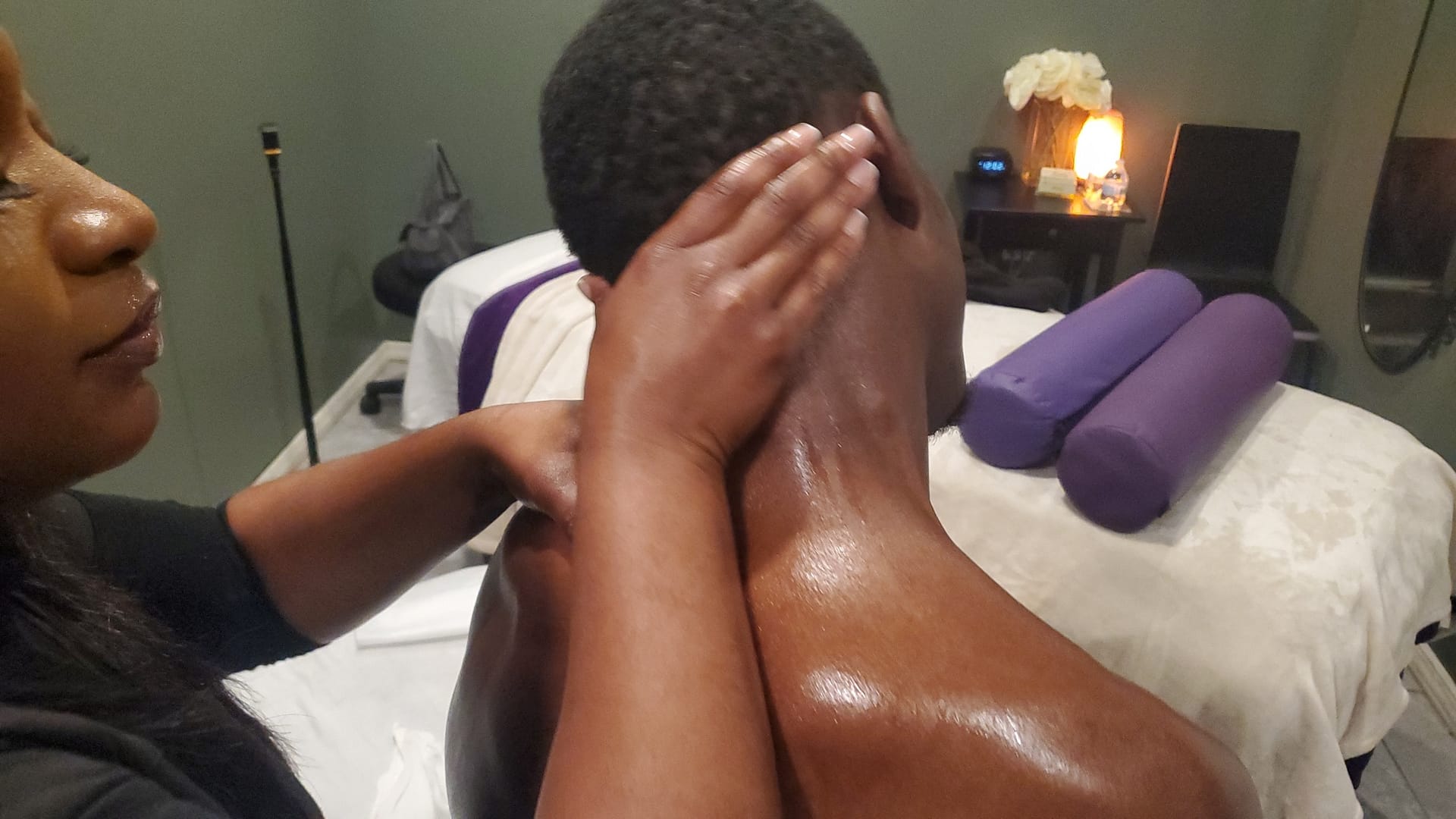 Massage therapist stretching clients neck