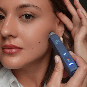 Woman holding TMJ pen to to the left side of her face