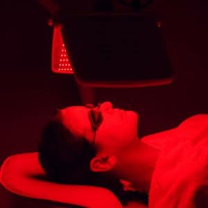 Woman laying down ib a room with redlight