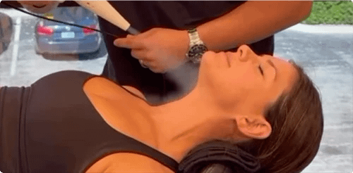 Woman getting her face sprayed with cryotherapy