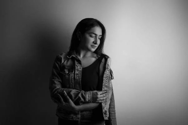A black and white photo of a person in a denim jacket.