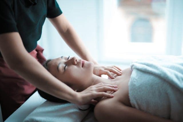 A woman lying on her back while getting a massage