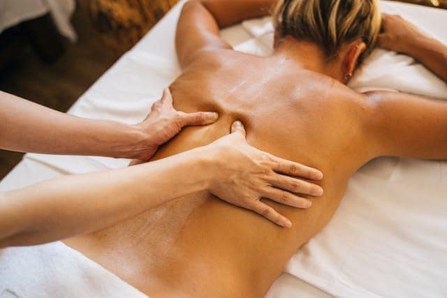 A person massaging a client’s back