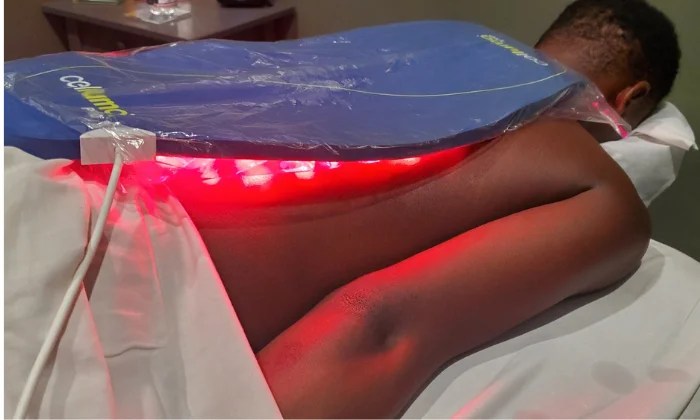 man laying on massage table with celluma panel on his back
