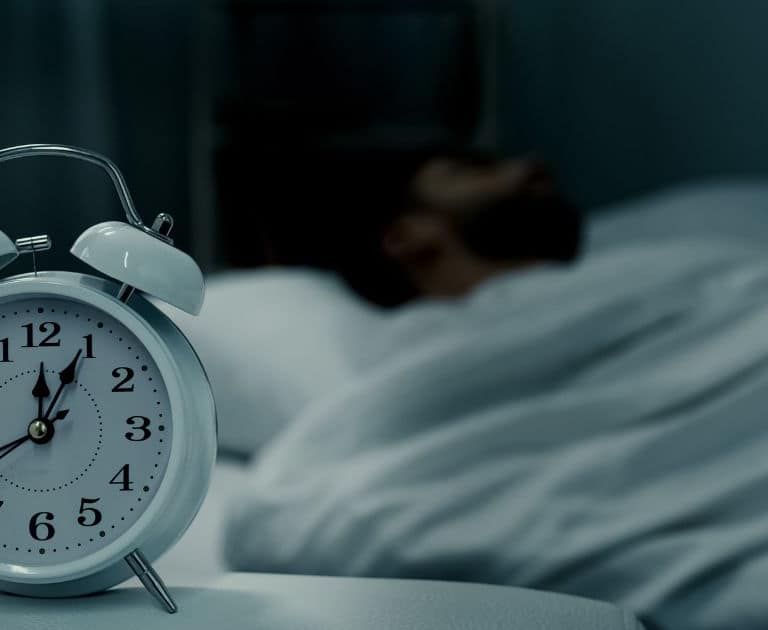 clock with person sleeping in the bed