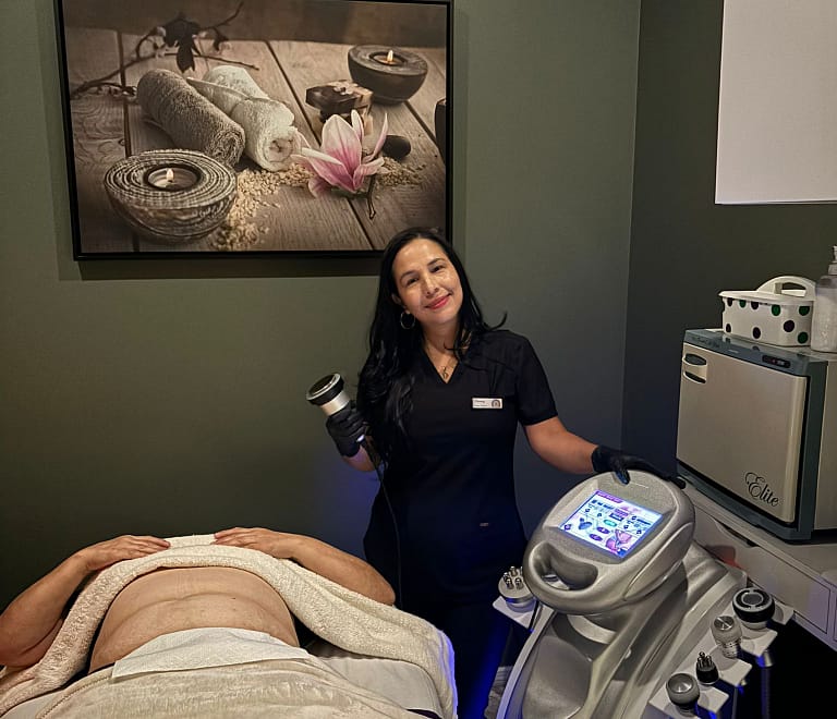 therapist holding cavitation device while woman lay on table