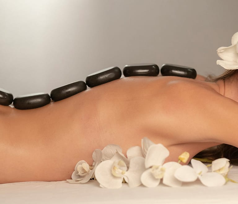 Woman receiving a relaxing hot stone massage on a massage table