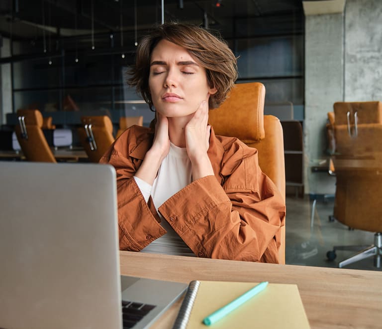 Image of woman feels pain, massages her neck, feels tension in muscles after long day of sitting and working in office.