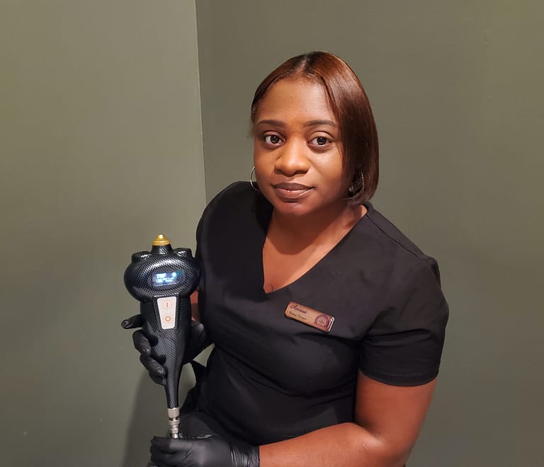 Female therapist in scrubs holding cryotherapy device