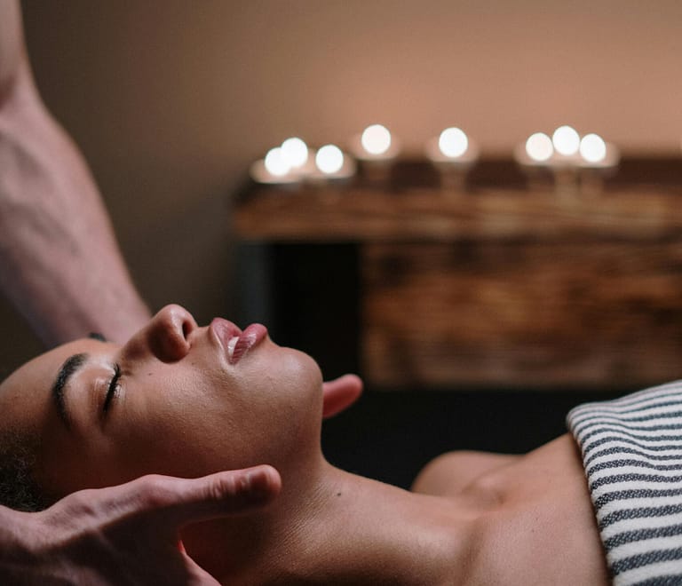 Woman gets neck massage for burnout from massage therapist at spa
