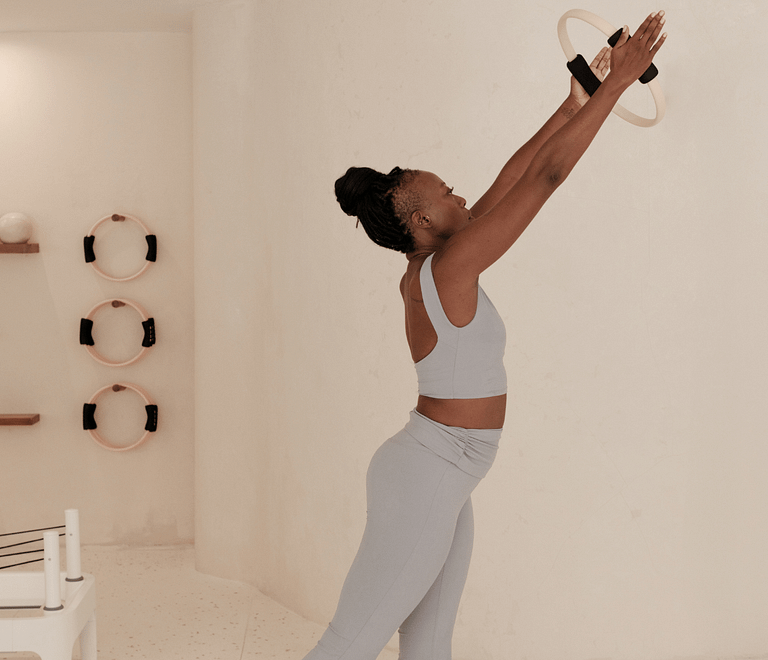 woman stretching with her hands towards the ceiling
