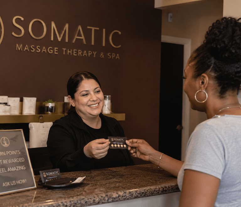 woman exchanging gift card at the spa desk