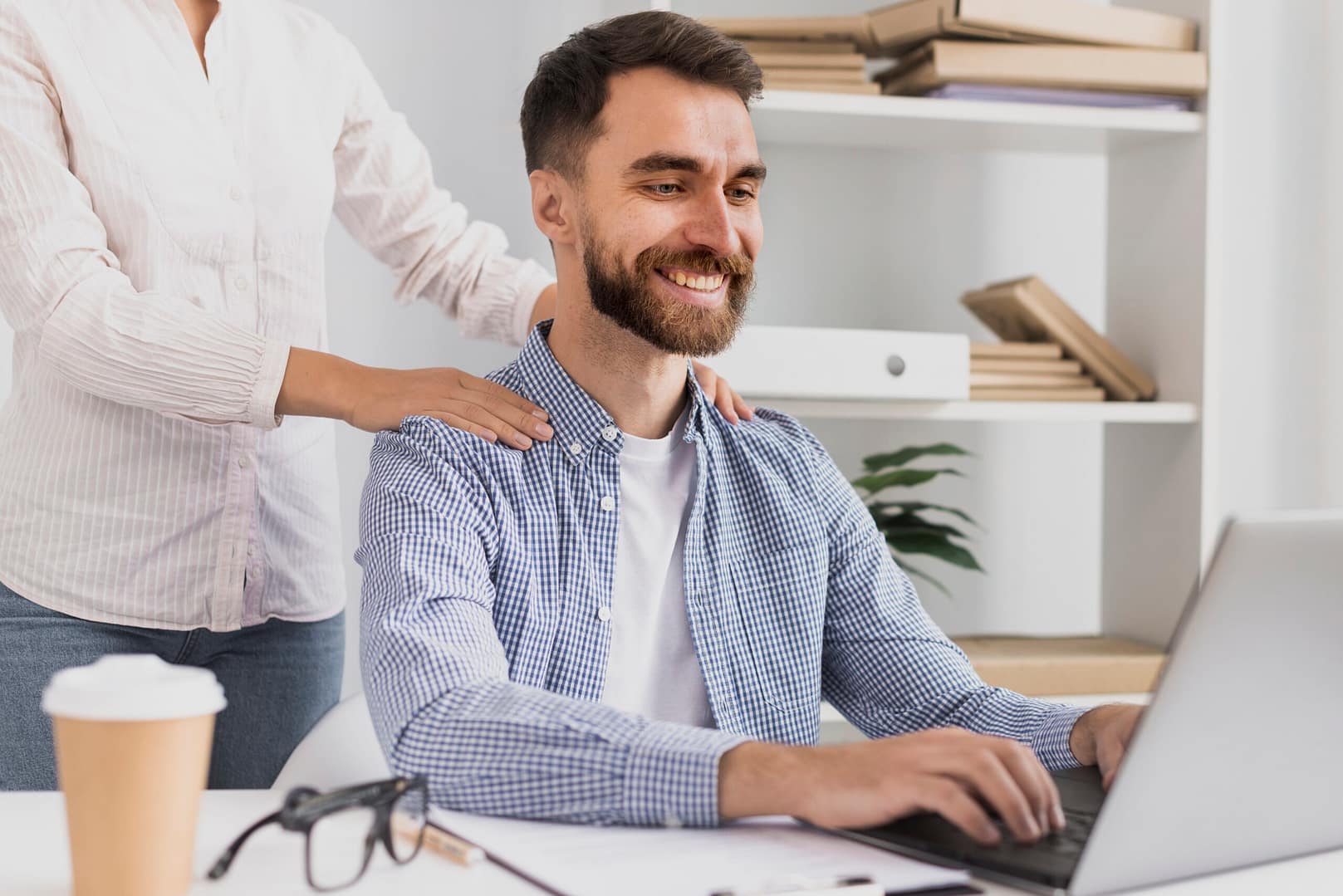 White young male having a massage at work at his desk as part of the employee wellness prgoram