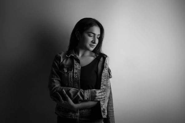 A black and white photo of a person in a denim jacket.