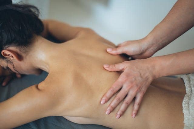A woman lying on her stomach while getting a massage